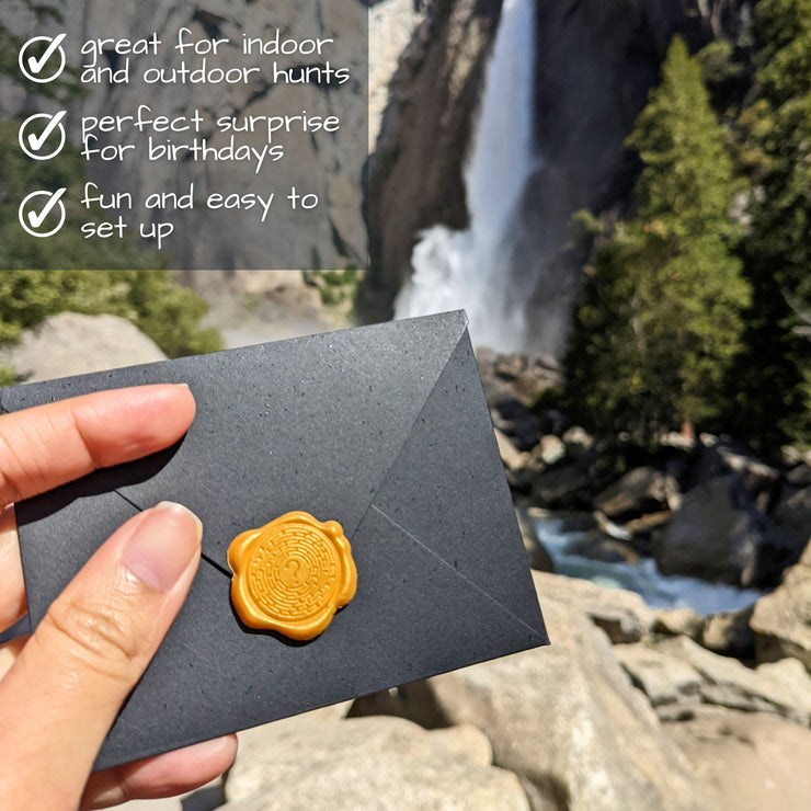 diy scavenger hunt showing black envelope with gold wax seal in front of waterfall